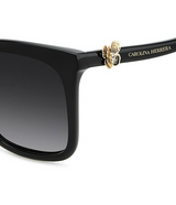 Close-up of Carolina Herrera HER0394/G/S Women Sunglasses with a gold butterfly detail on the temple, Carolina Herrera branding in gold on the arm, and dark gradient-tinted lenses.