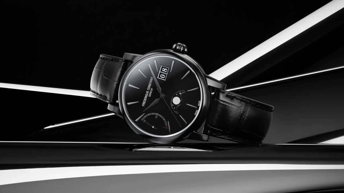 A sleek black luxury wristwatch with a leather strap, silver hands, and minimalist dial rests on a reflective black and white surface with abstract geometric lighting in the background.