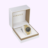 The Versace Watches VE6A00623 V-Code gold watch with a black dial is showcased in an open white and gold Versace-branded box against a light background.
