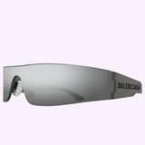 Close-up of Balenciaga Sunglasses BB0041S-002 99 in wraparound gray design, featuring “BALENCIAGA” in black on the side, set against a pastel background—a statement piece for bold designer eyewear lovers.