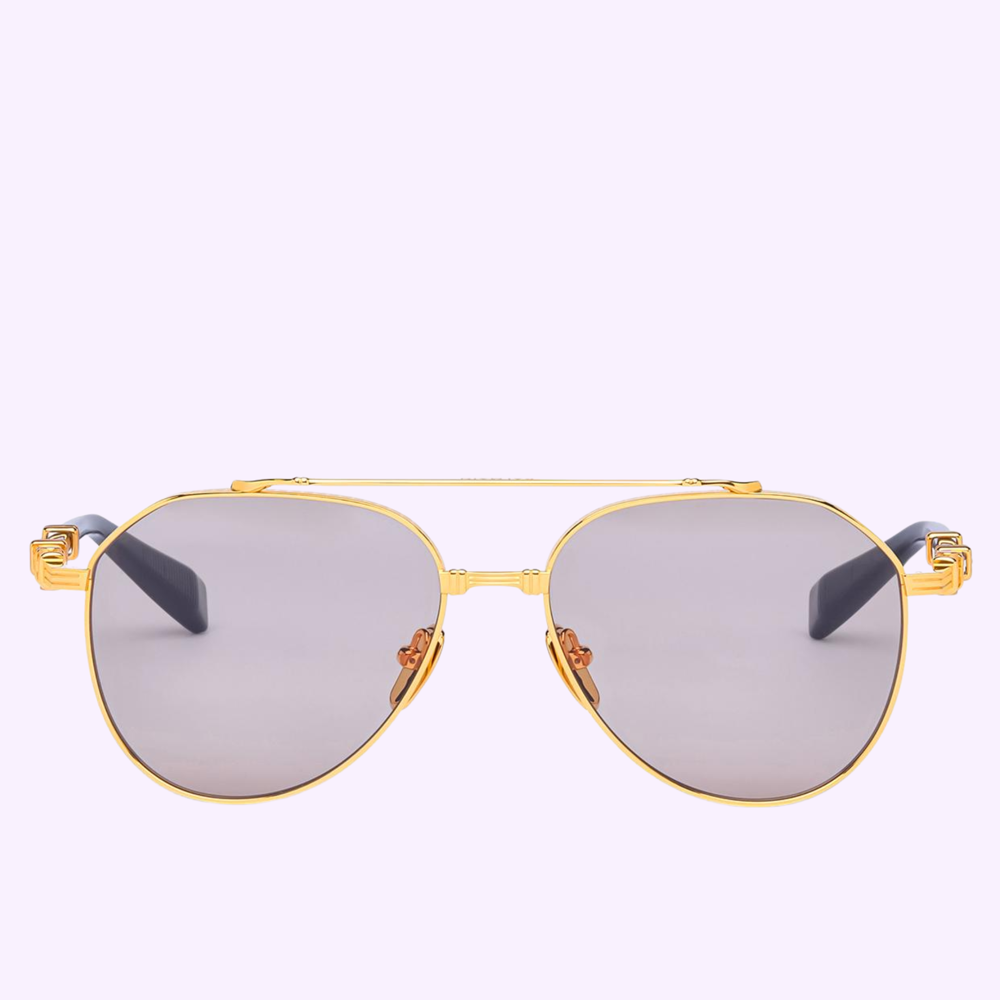 Balmain Sunglasses BRIGADE - VII BPS-186A-57 feature a gold aviator frame, gray tinted lenses, a double bridge, and decorative accents on the upper corners, shown against a pale lavender background.