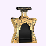The Bond No. 9 Dubai Black Sapphire 3.4 EDP Unisex Perfume by Bond No. 9 Perfumes features a unique, ornate bottle with gold patterns, a black center, and domed cap—showcasing elegant unisex luxury in every detail.
