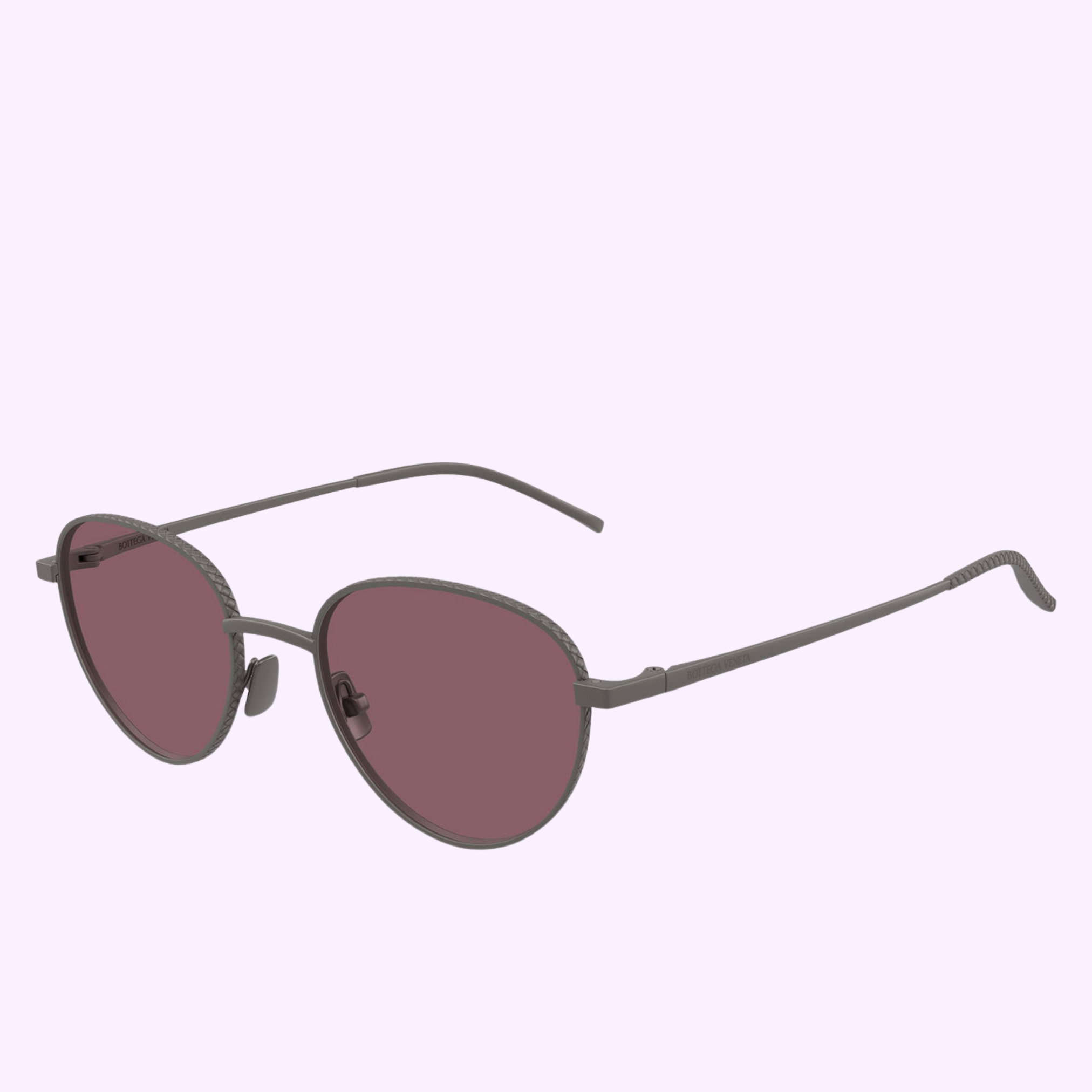 The Bottega Veneta Sunglasses BV1966S-003 50 feature round, metal frames with thin arms and dark pink-tinted lenses, showcased against a light lavender background.