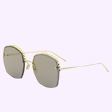 The Boucheron BC0053S 004 Sunglasses for women by Boucheron Sunglasses feature gold frames in a square silhouette, slightly tinted lenses, and slender metal arms. Displayed against a light purple background, these designer sunglasses embody elegance.