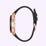A side view of the Bulova Watches 98A177 Maquina Automatic Men's watch with a rose gold case and black silicone strap, set against a light purple background.