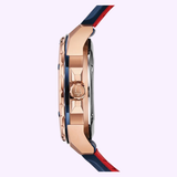 Side view of the Bulova 98A227 Marine Star Automatic by Bulova Watches, featuring a rose gold case, trident-engraved crown, and blue silicone strap—set against a light pink background.