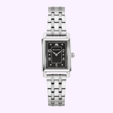 The Bulova Watches The Very Thought Of You 96L341 (UPC: 042429603615) features a stainless steel ladies’ wristwatch with a rectangular black dial, silver markers, and link band, shown on a light purple background.