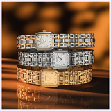 Three Bulova Watches Goddess of Time 97P184, featuring rectangular faces and woven metal bands in gold-tone, silver, and two-tone, are stacked before a blurred orange-black backdrop, highlighting their enduring elegance.