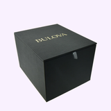 A black, square box with "BULOVA" in gold on the lid, set against a light background—ideal for gifting the Bulova Watches Goddess of Time Sophia 98P237.