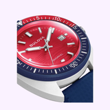 Close-up of the Bulova Watches Snorkel 98B474 Special Edition dive watch, featuring a striking red dial, silver hour markers and hands, a blue bezel, and a robust HNBR rubber strap with a unique textured pattern. The date window is positioned at 3 o’clock.