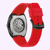 The Bulova Watches Maquina 98A341 showcases its visible mechanical movement within a sleek black case, complemented by a steel back and a bold red silicone strap, elegantly presented from the back against a light background.
