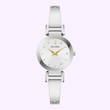 The Bulova Watches Modern 96P241, a silver ladies' bangle watch with a round white face, gold hands, crystal markers, and a slim metal band, is displayed on a light lavender background.