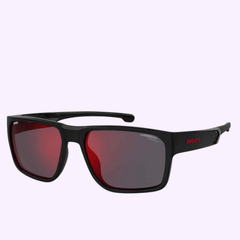 Black rectangular CARRERA CARDUC-029/S 0807-H4-BLACK Sunglasses with red-tinted lenses. The word DUCATI is featured in red on the left temple arm, while CARRERA appears in white near the left lens, confirming their authenticity as Carrera Sunglasses. Set against a light purple background for a stylish touch from your Miami authorized dealer.