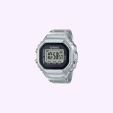 The CASIO RING WATCH CRW001-1 by G-Shock Watches is a silver digital watch crafted with metal injection molding, showcasing a square face and a black digital display reading 10:58:50 against a light purple background.