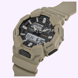 The CASIO G-Shock Watch Analog-Digital GA010-5A by G-Shock Watches showcases a rugged tan design with both analog and digital displays, clearly labeled buttons for mode, adjust, reset, and start. Featuring Carbon Core Guard technology for enhanced durability and offering up to 10-year battery life, this timepiece is presented against a light background.