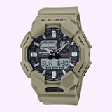 The CASIO G-Shock Watch Analog-Digital GA010-5A by G-Shock Watches features a tan design with both analog and digital displays, a black face highlighted by white accents, and rugged buttons encircling the bezel. Engineered with Carbon Core Guard technology for superior durability, this watch offers a 10-year battery life and includes a digital screen that clearly shows the time, date, and various modes.