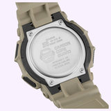 Close-up of the back of a beige CASIO G-Shock Watch Analog-Digital GA010-5A by G-Shock Watches, featuring engraved details such as water resistance information, model number, and Carbon Core Guard on the stainless steel case back. The watch band and screws are also visible.