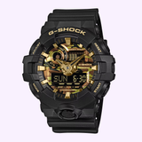 The CASIO G-Shock Watch Bold Camo Series GA700CF-1A by G-Shock Watches features a bold black and gold camouflage design, with both analog and digital displays that show the day, date, and time—perfectly combining striking style with practical functionality.