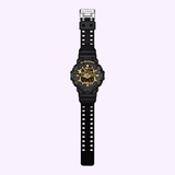 A CASIO G-Shock Watch from the Bold Camo Series (model GA700CF-1A) by G-Shock Watches, featuring a black design with a gold-accented face and both digital and analog displays, is displayed on a light purple background.