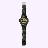 A CASIO G-Shock Watch Bold Camo Series GA700CMG-3A by G-Shock Watches, featuring a green camouflage pattern and both digital and analog displays for the time, date, and day, is shown on a light purple background.