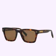 CHOPARD SUNGLASSES SCH337 DARK HAVANA by Chopard Sunglasses are featured here, styled in a brown tortoiseshell square frame inspired by the classic dark havana look. Displayed on a light purple background and angled to reveal both the front and side of the frames, these sunglasses feature dark tinted lenses for a sophisticated accent to any outfit.