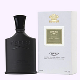 A sleek black bottle of Creed Green Irish Tweed 3.4 EDP by Creed Perfumes stands beside its elegant white and gold box, both displaying the Creed logo. This iconic men’s perfume contains 3.4 fl oz of fragrance.