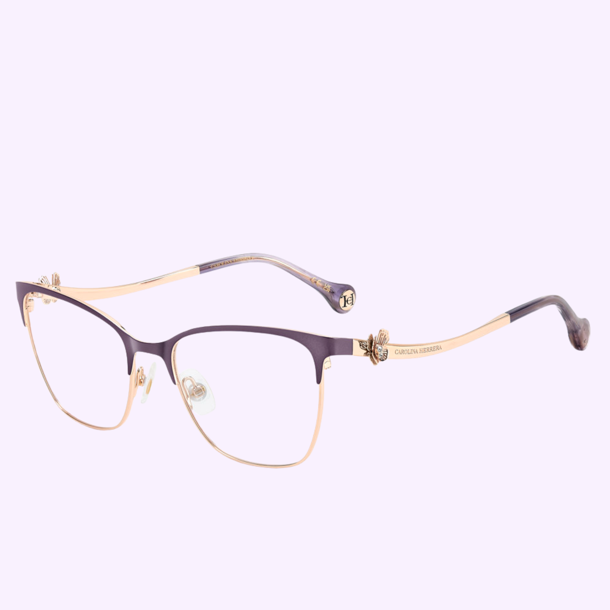 Violet and gold Carolina Herrera Optical Frames HER 0398 BSU, featuring a delicate butterfly detail on the hinges, are shown on a light purple background—a sophisticated addition to any eyewear collection.