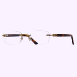 The Cartier CT0048O 004 53 Unisex Optical Frame by Cartier Sunglasses features rimless rectangular lenses, tortoiseshell-patterned temples, and gold accents on the bridge and hinges, shown against a light purple background.