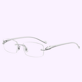 The Cartier Optical CT0061O 003 53 unisex rimless frame features silver metal temples, nose pads, and logo-engraved curved arms—displayed on a light lavender background. Available from an authorized Cartier dealer in Miami.