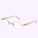 The Cartier CT0318O 004 52 Unisex Optical Frame by Cartier Optical showcases rimless eyeglasses with a gold bridge, transparent nose pads, and light pink temples, elegantly set against a pale lavender background.