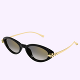 Cartier Sunglasses CT0634S-001 52 by Cartier Sunglasses feature cat-eye black frames, gold arms, and black spotted accents near the hinges, set against a light purple background for a sleek, luxurious look.