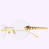 A close-up of luxury eyewear showcases the Cartier Optical Frames CT0637O-001 56 by Cartier Sunglasses, featuring rimless optical frames with elegant gold temples. The temple tip is adorned with a distinctive gold jaguar head with black spots, creating a striking animal motif. The backdrop is a solid light lavender color.