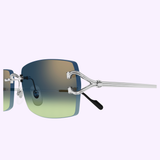 Close-up of Cartier Sunglasses CT0550S-008 56, featuring gradient blue-to-green lenses, silver horsebit temples, and black ear tips, displayed against a light purple background.