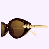A close-up of Cartier Sunglasses CT0634S-002 52 shows their brown tortoiseshell frame, gold temples, and signature gold panther head accent near the hinge—a striking display of Cartier luxury.