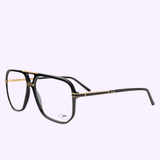 The Cazal 6025-01 Black-Gold Women Sunglasses by Cazal Sunglasses feature a bold, oversized square frame in striking black and gold, displayed against a pale lavender background. Reminiscent of classic Cazal designs, these sunglasses offer clear lenses enhanced with subtle gold accents on the bridge and temples.