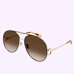 The Chloe CH0145S-003 61 Sunglass WOMAN METAL by Chloe Sunglasses features gold aviator frames with dark gradient lenses, a sleek thin metal construction, and a signature double bridge design—an epitome of luxury eyewear. Displayed against a light purple background, these sunglasses make an elegant statement piece for women’s fashion.