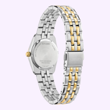 The Citizen Watches Eco-Drive Corso EW2299-50A is a women’s watch by Citizen Watches, featuring an elegant two-tone stainless steel design with a silver and gold metal band. Viewed from the back, the round case showcases a gold crown and engraved details on the back cover, emphasizing its refined craftsmanship.