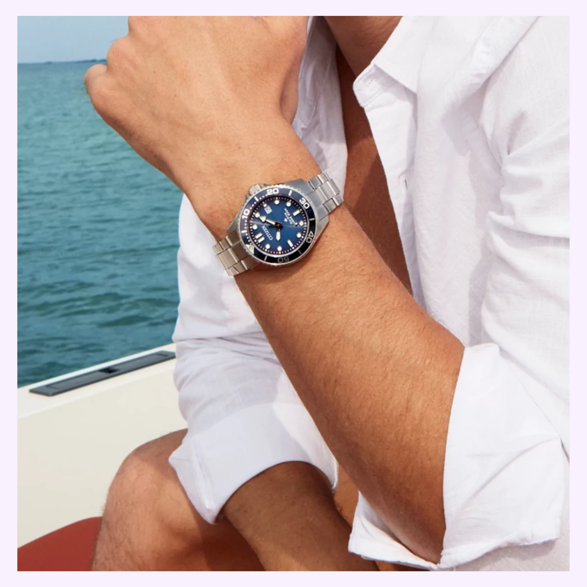A person in a white shirt sits on a boat by the water, wearing a Citizen Watches Promaster Dive BN0260-54L with a blue face on their left wrist.