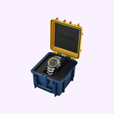The Citizen Watches Promaster Navihawk CA4667-53L, a striking silver stainless steel timepiece with a blue and yellow dial, is presented inside an open, rugged blue and yellow protective case featuring the Citizen Watches logo on the lid.