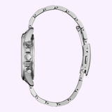 Side view of the Citizen AT0200-56L Chandler Eco-Drive men’s watch, featuring a silver stainless steel link bracelet, visible crown and pushers, open clasp, and slim chronograph profile against a light purple background.