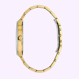 A Bulova Watches Futuro 97D115 Men's gold-tone stainless steel watch is displayed vertically with its band shaped like an “O” against a light purple background.