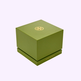 A green square gift box with a gold Tory Burch logo and lettering, ideal for presenting the Tory Burch Watches THE KIRA SQUARE Women TBW6021, displayed on a light pink background.