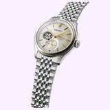 The Seiko Luxe Watches Presage Classic Series SPB480 features a metal link band, open-heart dial, gold hour markers, and a subdial, exemplifying Japanese mechanical watchmaking, shown on a light purple background.