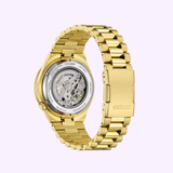 The Citizen Watches TSUYOSA Shore NJ0232-53X wristwatch in yellow gold-tone stainless steel is shown from the back, revealing its automatic movement and inner mechanics. The bracelet’s clasp is engraved with the Citizen Watches logo.