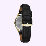 The Bulova 44B118 Dress Caravelle men’s watch by Caravelle Watches By Bulova features a black textured leather strap, gold buckle clasp engraved with CARAVELLE, and an engraved caseback for a refined, luxurious look.