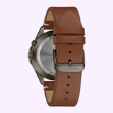 The Bulova 45C119 Classic Caravelle men's watch by Caravelle Watches By Bulova features a brown leather strap with a "CARAVELLE" engraved metal buckle, shown from the back against a light background.