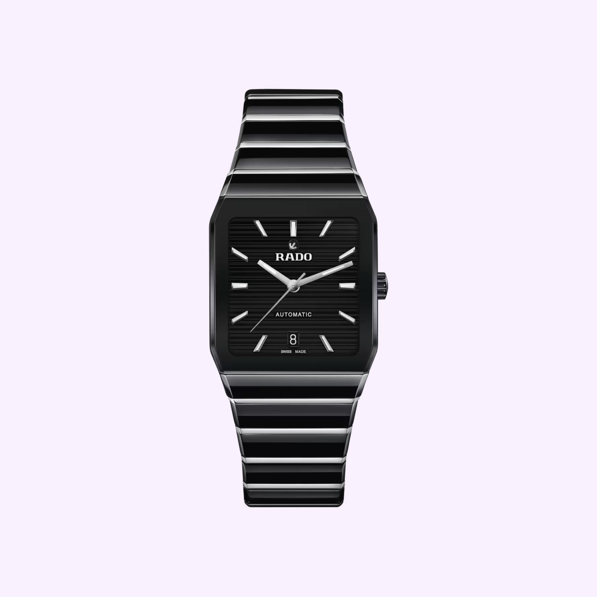 The Rado Anatom Automatic Men’s Watch R10201152 by Rado Watches features a sleek black rectangular case, high-tech ceramic bracelet, minimalist black dial with silver hands and markers, plus a date window at 6 o’clock, set on a light purple background.