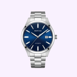The Bering Watches Classic 19842-707 is a silver women’s watch featuring Scandinavian minimalism, a metallic band, blue dial, silver hour markers and hands, and a date display at 3 o’clock.