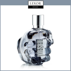 The Diesel Only The Brave 2.5oz EDT Men Perfume by Diesel Perfumes features a clear glass bottle shaped like a clenched fist with DIESEL embossed, topped by a metallic cap, displayed on white with the LEXOR MIAMI logo above.