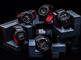 Five CASIO G Shock 5600 SERIES DW5600HR-1 watches by G-Shock Watches, in black and red, stand on stacked metallic gray blocks against a dark background, each angled to highlight its rugged digital or analog face.